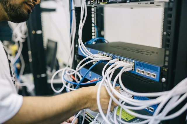 pekerja sedang mengatur kabel untuk cloud server