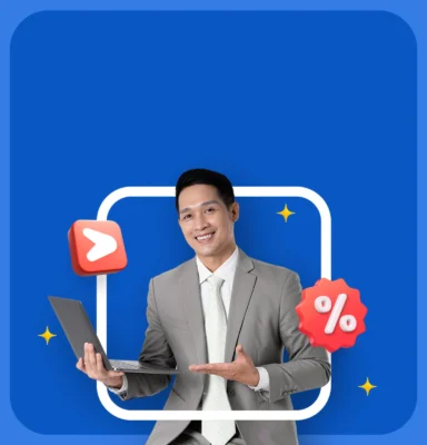 Seorang pria mengenakan setelan rapi memegang laptop, tersenyum dan menunjuk layar; ikon persentase dan tombol putar mengambang di sekelilingnya, latar belakang biru dengan bingkai putih.